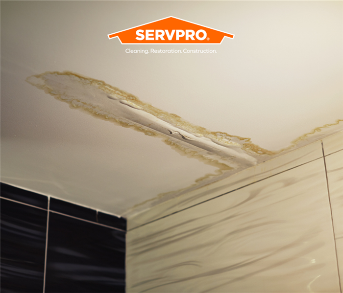 ceiling with water damage and SERVPRO logo