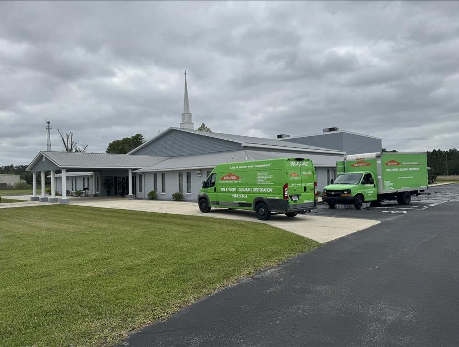 two servpro vehicles parked outside of a church for water damage mitigation services